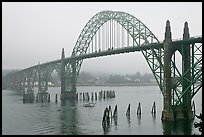 Small boat exiting harbor under Yaquina Bay Bridge. Newport, Oregon, USA