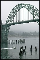 Small boat heading towards ocean under Yaquina Bay Bridge. Newport, Oregon, USA ( color)