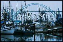 Commercial fishing boats and Yaquina Bay Bridge at dawn. Newport, Oregon, USA (color)