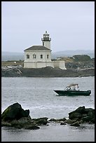 Small boat and Coquille River lighthouse. Bandon, Oregon, USA