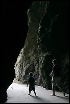 Father and son walking towards the light in sea cave. Bandon, Oregon, USA ( color)
