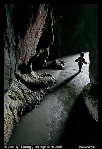 Infant walking out of sea cave. Bandon, Oregon, USA