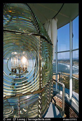 Rotating light inside Cape Blanco Lighthouse tower and landscape. Oregon, USA