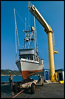 Fishing boat lifted from water by huge hoist, Port Orford. Oregon, USA