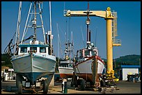 Fishing boats parked on deck with hoist behind, Port Orford. Oregon, USA (color)