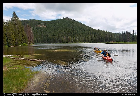 Parents towing children in kayak, Devils Lake. Oregon, USA (color)