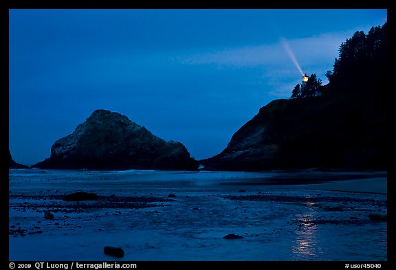 Heceta Head and lighthouse beam from beach by night. Oregon, USA (color)