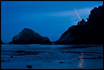 Heceta Head and lighthouse beam from beach by night. Oregon, USA