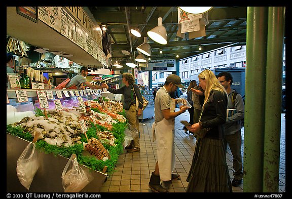 Countermen offer fish samples, Pike Place Market. Seattle, Washington (color)