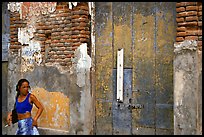 Woman in front of a decaying brick wall, Ponce. Puerto Rico