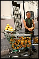 A man peels oranges to make an orange drink, which is drunk from the fruit itself, Ponce. Puerto Rico (color)