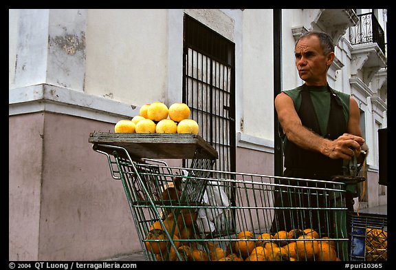 Man peeling oranges to make a drink, drunk from the fruit itself, Ponce. Puerto Rico