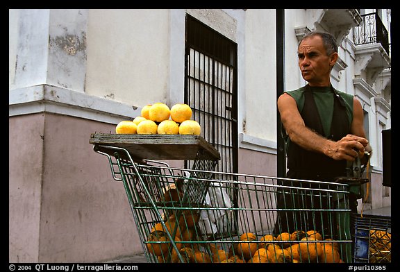 Man peeling oranges to make a drink, drunk from the fruit itself, Ponce. Puerto Rico (color)
