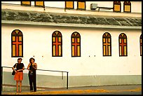 Two women standing in front of a church, La Parguera. Puerto Rico (color)