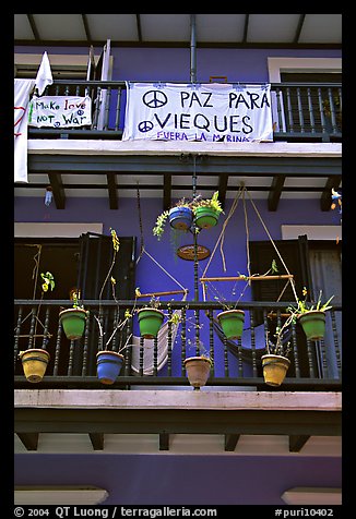 Facade of house painted in blue with plant pots and balconies. San Juan, Puerto Rico