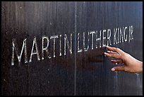 Hand touching the letters Martin Luther King on the Civil Rights Memorial wall. Montgomery, Alabama, USA
