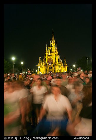 Crowds walking away from Cinderella Castle at night. Orlando, Florida, USA