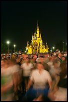 Crowds walking away from Cinderella Castle at night. Orlando, Florida, USA (color)