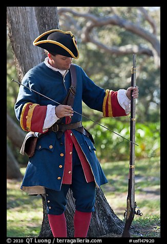 Man useing ramrod on musket, Fort Matanzas National Monument. St Augustine, Florida, USA (color)