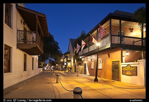 Old street and historic buildings with flags by night. St Augustine, Florida, USA