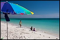 Beach with unbrella, children playing and woman strolling,. The Keys, Florida, USA (color)