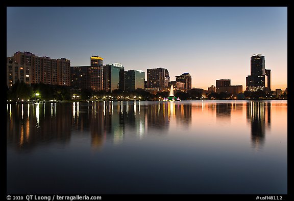 Orlando skyline at sunset reflected in lake Eola. Orlando, Florida, USA