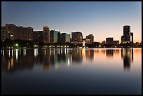 Orlando skyline at sunset reflected in lake Eola. Orlando, Florida, USA