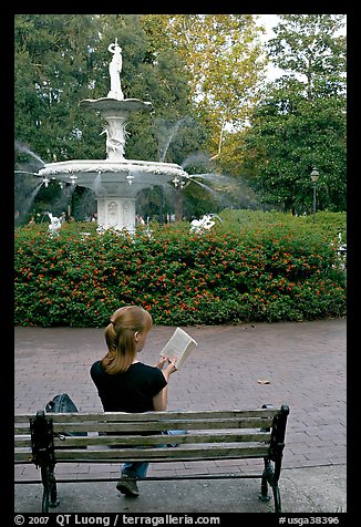 Woman reading a book in front of Forsyth Park Fountain. Savannah, Georgia, USA (color)