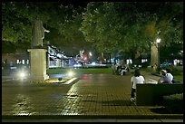 Square by night with people sitting on benches. Savannah, Georgia, USA