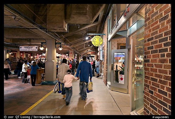 Family walking in front of Underground Atlanta store with historic brick wall. Atlanta, Georgia, USA (color)