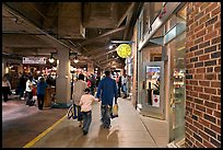 Family walking in front of Underground Atlanta store with historic brick wall. Atlanta, Georgia, USA ( color)