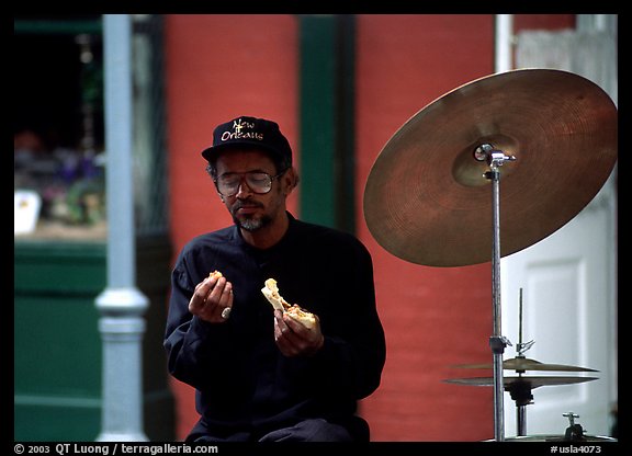 Street musician taking a lunch break, French Quarter. New Orleans, Louisiana, USA (color)