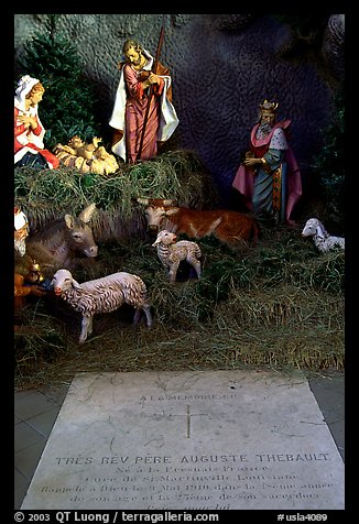 Tombstone of a French priest, and figures inside a replica of the Lourdes grotto, church Saint-Martin-de-Tours, Saint Martinville. Louisiana, USA (color)