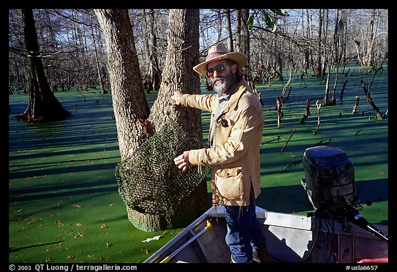 Bayou guide of French descent retriving net,  Lake Martin. Louisiana, USA