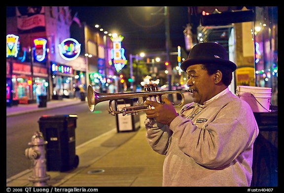 African-American man playing trumpet on Beale Street by night. Memphis, Tennessee, USA