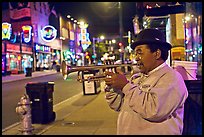 African-American man playing trumpet on Beale Street by night. Memphis, Tennessee, USA