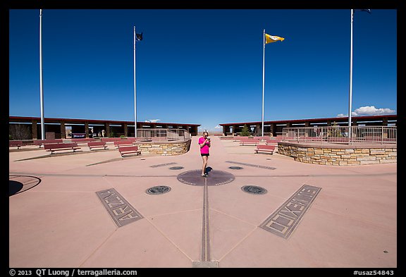 Woman straddling the territory of four states. Four Corners Monument, Arizona, USA