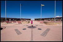 Woman straddling the territory of four states. Four Corners Monument, Arizona, USA ( color)