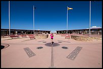 Woman straddling the territory of four states. Four Corners Monument, Arizona, USA (color)