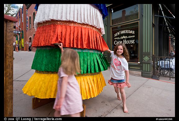 Girls spin tibetan prayer wheel. Telluride, Colorado, USA