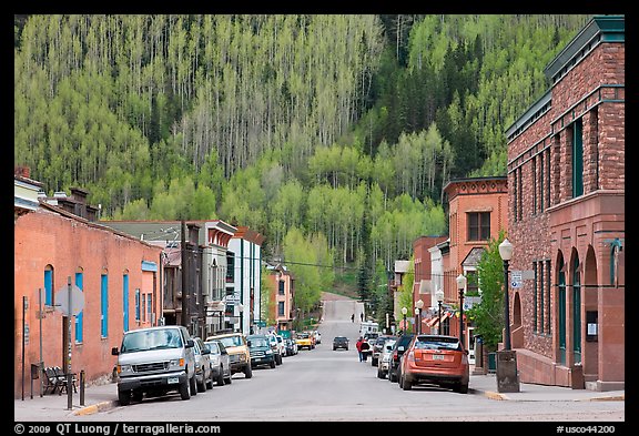 Historic brick buildings and slope with newly leafed aspens. Telluride, Colorado, USA (color)