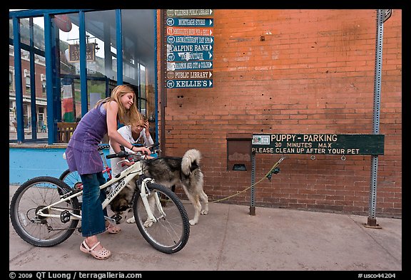 Girls on bikes and puppy parking. Telluride, Colorado, USA (color)