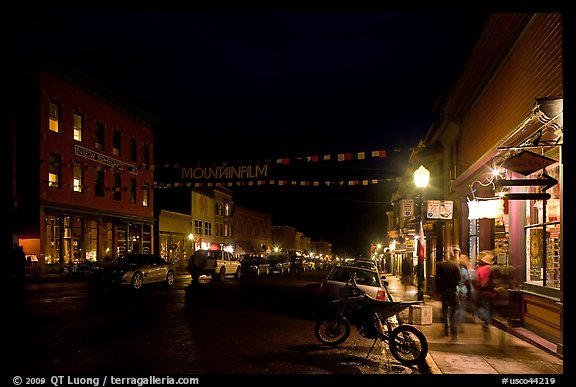 People walking by store on Colorado Street by night. Telluride, Colorado, USA (color)