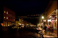 People walking by store on Colorado Street by night. Telluride, Colorado, USA