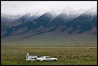 Car and pickup cover below snowy peaks. Colorado, USA ( color)