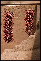 Strings of red pepper hanging from adobe walls. Taos, New Mexico, USA