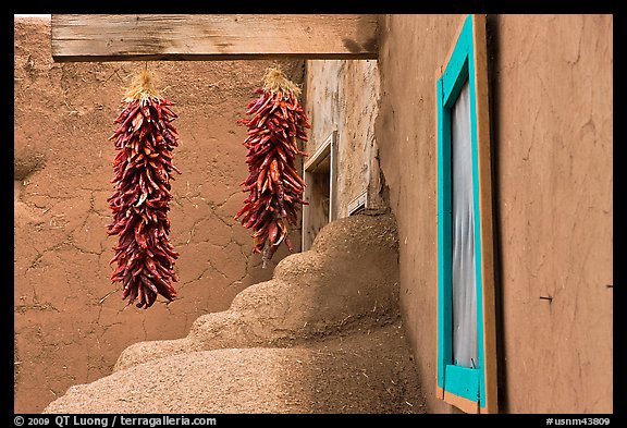 Ristras, adobe walls, and blue window. Taos, New Mexico, USA