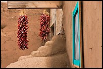 Ristras, adobe walls, and blue window. Taos, New Mexico, USA