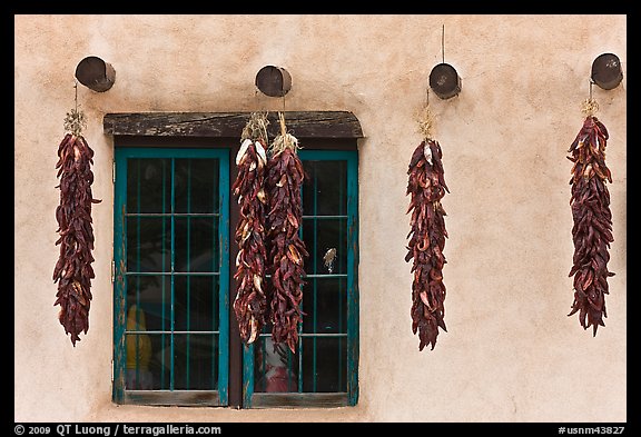 Yellow wall with ristras and blue window. Taos, New Mexico, USA