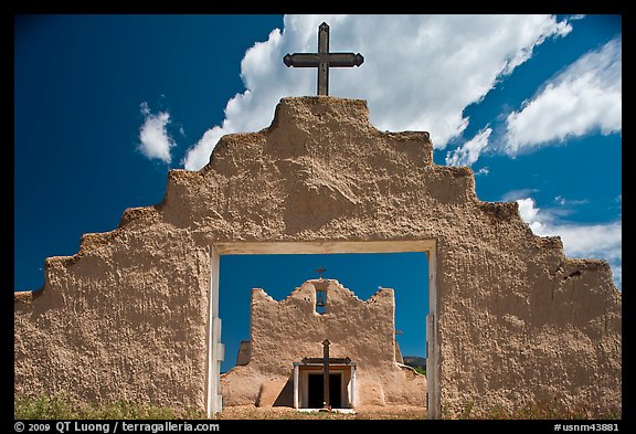 Adobe church framed by entrance in earthen wall, Picuris Pueblo. New Mexico, USA